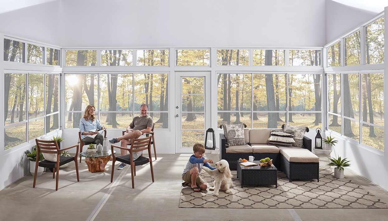 Family playing with dog in Eze-Breeze porch enclosure.