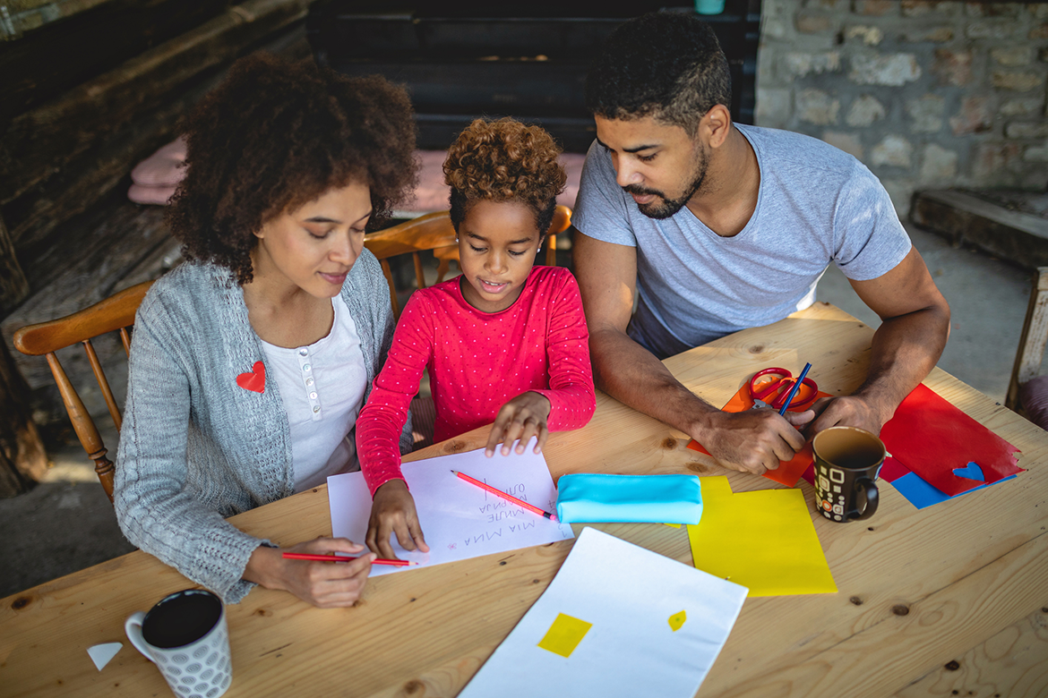 Family works together on homework in their house.